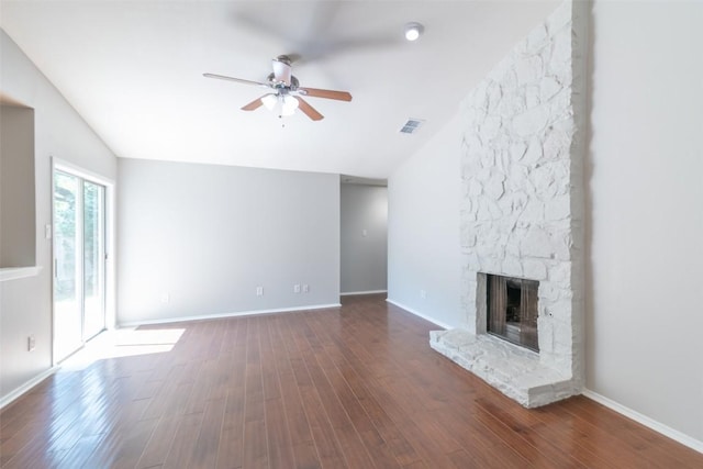12602 Pluto Ln, Austin, TX 78727 - unfurnished living room featuring a ceiling fan, dark wood finished floors, vaulted ceiling, and a stone fireplace