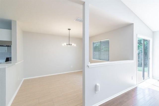12602 Pluto Ln, Austin, TX 78727 - spare room featuring wood finished floors and a chandelier