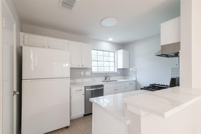 12602 Pluto Ln, Austin, TX 78727 - kitchen featuring freestanding refrigerator, stainless steel dishwasher, a peninsula, wall chimney exhaust hood, and backsplash