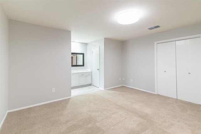 12602 Pluto Ln, Austin, TX 78727 - unfurnished bedroom featuring light colored carpet, a closet, and connected bathroom