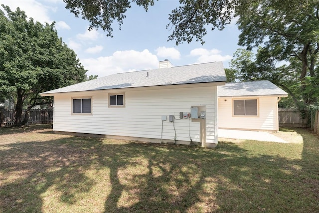 12602 Pluto Ln, Austin, TX 78727 - back of house with a fenced backyard, a chimney, and roof with shingles