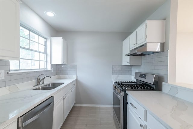 12602 Pluto Ln, Austin, TX 78727 - kitchen with appliances with stainless steel finishes, under cabinet range hood, white cabinets, light stone countertops, and backsplash