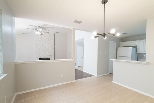 12602 Pluto Ln, Austin, TX 78727 - unfurnished living room with light wood finished floors, a chandelier, ceiling fan, and a fireplace