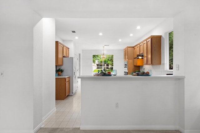106 Ranch House Cv, Georgetown, TX 78633 - kitchen featuring white refrigerator with ice dispenser, recessed lighting, a peninsula, light countertops, and light tile patterned floors
