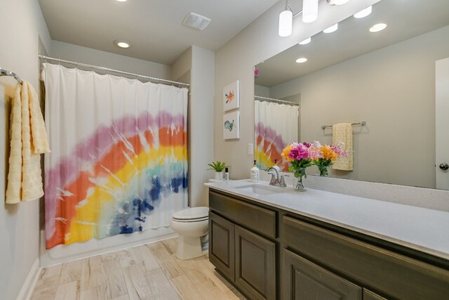 full bath featuring toilet, vanity, recessed lighting, and curtained shower