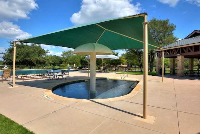 community pool with a gazebo and a patio area