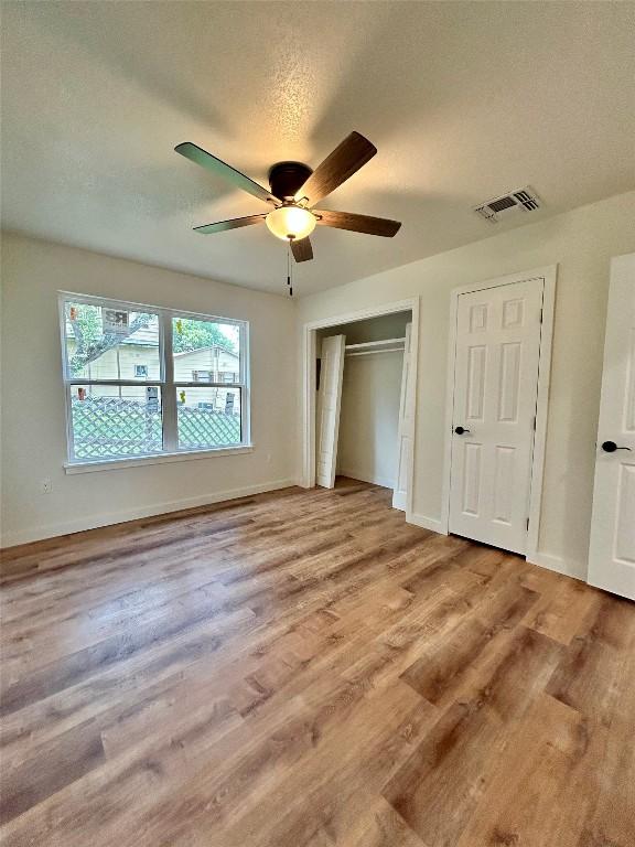 1127 Greenhill Dr, Canyon Lake, TX 78133 - unfurnished bedroom featuring wood finished floors and a ceiling fan