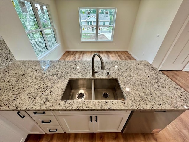 1127 Greenhill Dr, Canyon Lake, TX 78133 - kitchen featuring light stone countertops, light wood finished floors, and white cabinets
