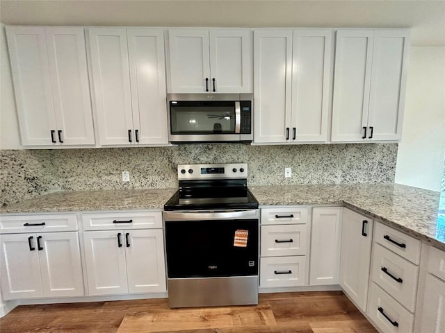 1127 Greenhill Dr, Canyon Lake, TX 78133 - kitchen with stainless steel appliances, white cabinets, and light wood-style flooring