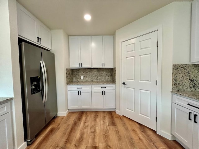 1127 Greenhill Dr, Canyon Lake, TX 78133 - kitchen featuring stainless steel fridge with ice dispenser, white cabinetry, light wood-style floors, and tasteful backsplash