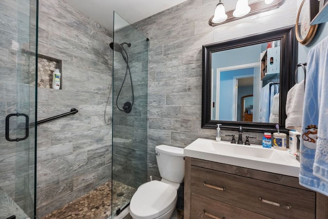 401 Patriot Way, Georgetown, TX 78626 - bathroom featuring a stall shower, vanity, toilet, tile walls, and decorative backsplash