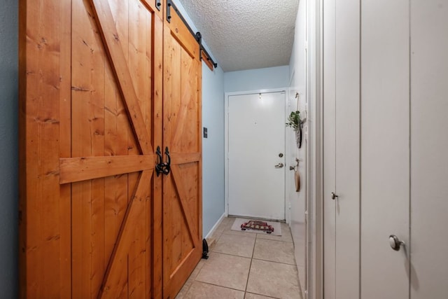 401 Patriot Way, Georgetown, TX 78626 - hallway with a barn door, a textured ceiling, and light tile patterned floors