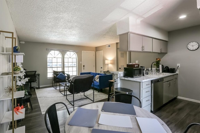 101 E 33rd St Unit 107, Austin, TX 78705 - kitchen with stainless steel appliances, a sink, dark wood-style flooring, light countertops, and a textured ceiling