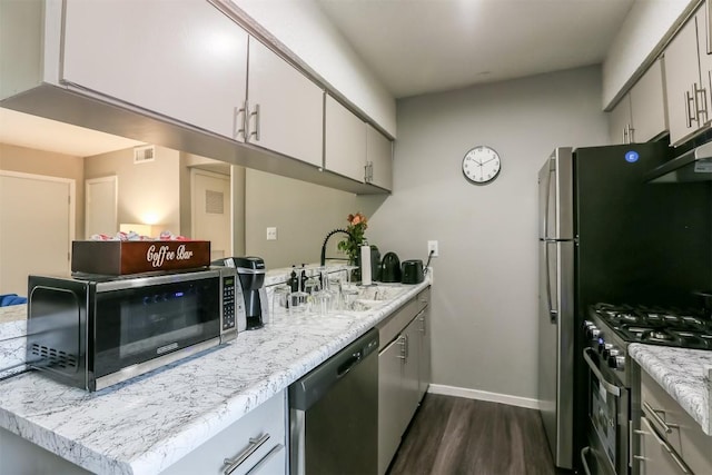 101 E 33rd St Unit 107, Austin, TX 78705 - kitchen featuring appliances with stainless steel finishes, a sink, dark wood-style floors, and baseboards