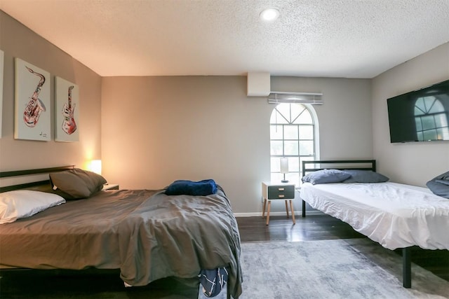 101 E 33rd St Unit 107, Austin, TX 78705 - bedroom with wood finished floors, a textured ceiling, and baseboards