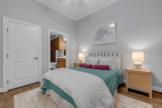 101 W Bank Unit 43, Llano, TX 78657 - bedroom featuring wood finished floors, baseboards, ensuite bathroom, and a ceiling fan