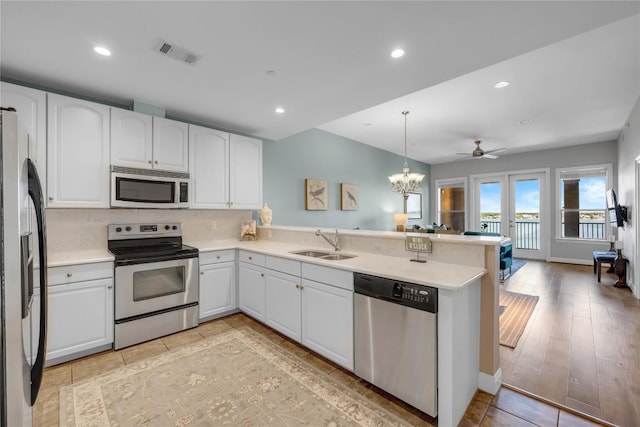 101 W Bank Unit 43, Llano, TX 78657 - kitchen with appliances with stainless steel finishes, a sink, a peninsula, white cabinets, and recessed lighting