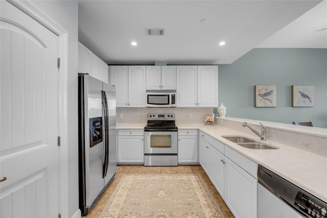 101 W Bank Unit 43, Llano, TX 78657 - kitchen with appliances with stainless steel finishes, a sink, white cabinets, light countertops, and recessed lighting