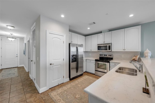 101 W Bank Unit 43, Llano, TX 78657 - kitchen featuring stainless steel appliances, a sink, white cabinetry, recessed lighting, and light tile patterned floors