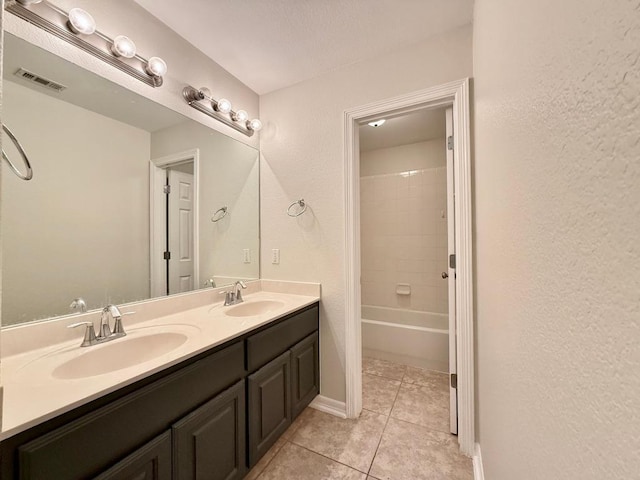 4233 Fairmeadow Dr, Round Rock, TX 78665 - full bath with double vanity, tile patterned flooring, bathing tub / shower combination, baseboards, and a textured wall