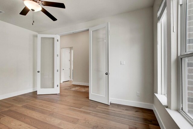 991 Arrowhead Ranch Blvd, Dripping Springs, TX 78620 - unfurnished bedroom with french doors, light wood-style flooring, baseboards, and a ceiling fan