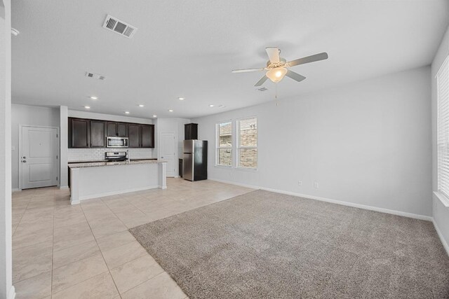 unfurnished living room with light tile patterned floors, ceiling fan, recessed lighting, and baseboards