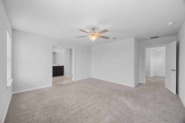 unfurnished room featuring a ceiling fan, light carpet, and baseboards