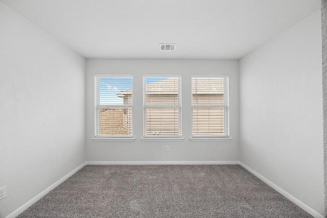 unfurnished room with carpet floors and baseboards