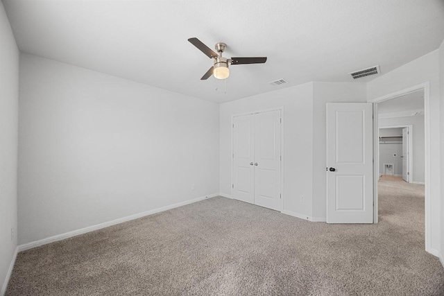 unfurnished bedroom featuring carpet floors, baseboards, a closet, and a ceiling fan
