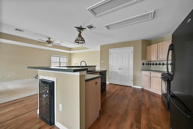 5705 Marchmont Ln, Austin, TX 78749 - kitchen with black appliances, beverage cooler, dark wood-style floors, a sink, and light brown cabinets