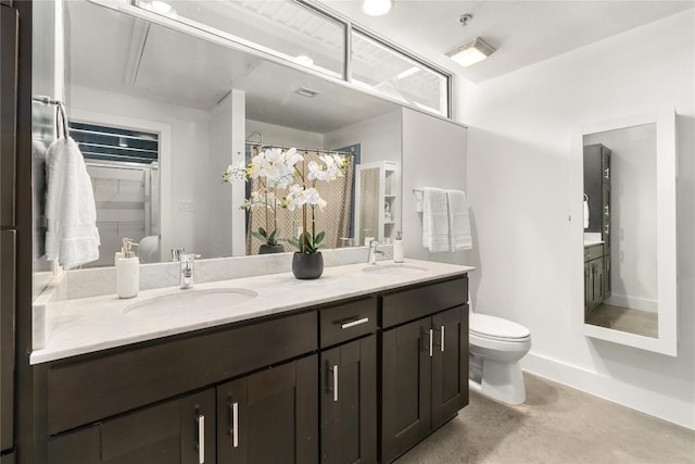 bathroom featuring double vanity, concrete floors, toilet, and baseboards