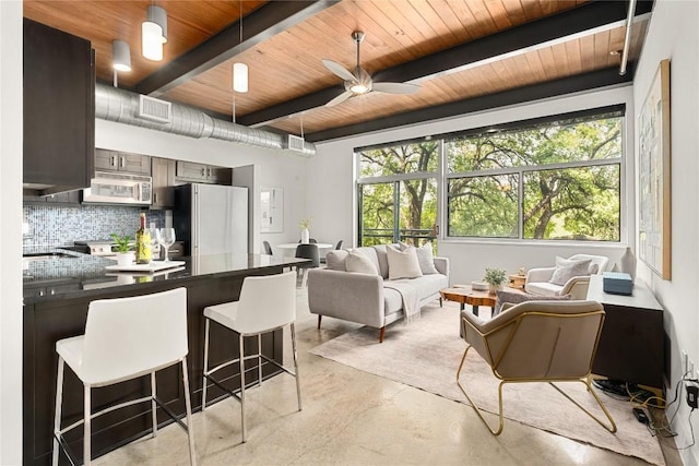 living area featuring finished concrete floors, wooden ceiling, beamed ceiling, and ceiling fan