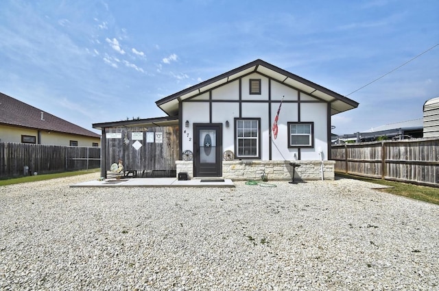 472 Mountain View Dr, Bandera, TX 78003 - view of front of property with a fenced backyard, a patio, stucco siding, and stone siding