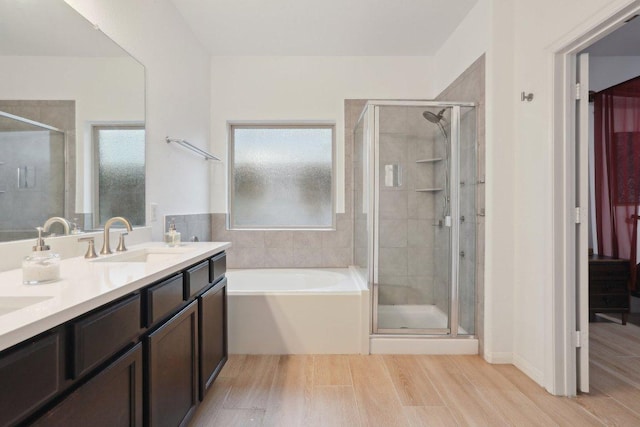 1107 Cadence Dr, Pflugerville, TX 78660 - bathroom with a shower stall, wood finished floors, a bath, and double vanity