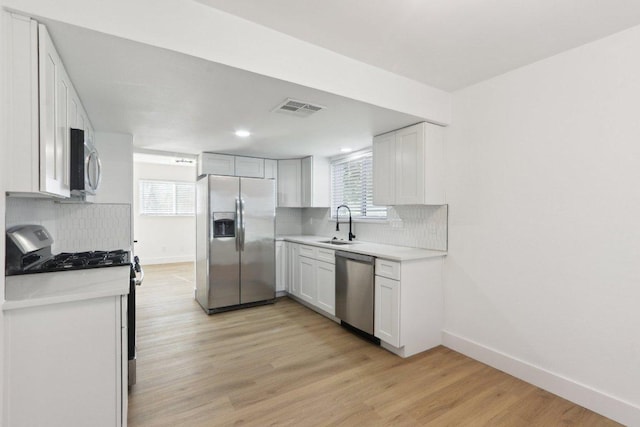 12127 Cabana Ln, Austin, TX 78727 - kitchen with appliances with stainless steel finishes, tasteful backsplash, light wood finished floors, light countertops, and recessed lighting