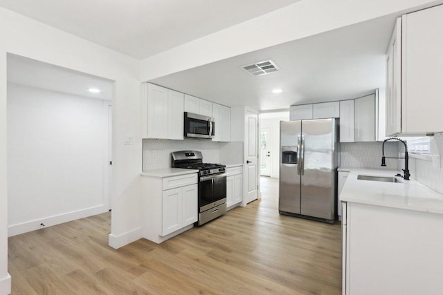 12127 Cabana Ln, Austin, TX 78727 - kitchen featuring appliances with stainless steel finishes, light countertops, recessed lighting, tasteful backsplash, and light wood-style flooring