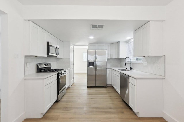 kitchen featuring stainless steel appliances, tasteful backsplash, recessed lighting, and white cabinetry