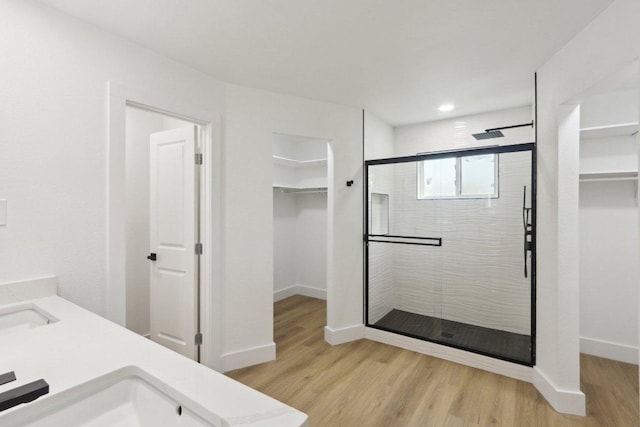 12127 Cabana Ln, Austin, TX 78727 - bathroom with a spacious closet, a shower stall, wood finished floors, double vanity, and recessed lighting