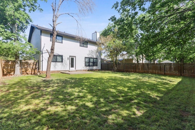 rear view of property featuring a chimney and a patio area