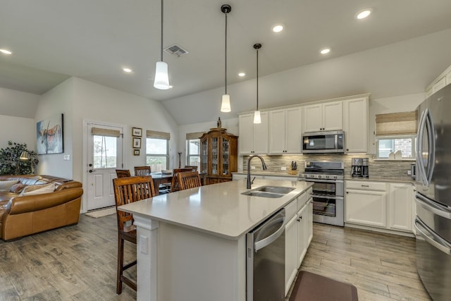 22208 Coyote Cave Trl, Spicewood, TX 78669 - kitchen with appliances with stainless steel finishes, a sink, lofted ceiling, decorative backsplash, and light countertops