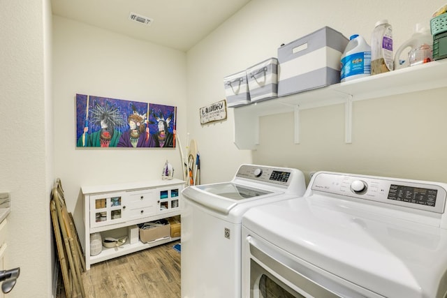 22208 Coyote Cave Trl, Spicewood, TX 78669 - laundry room with washing machine and dryer and wood finished floors