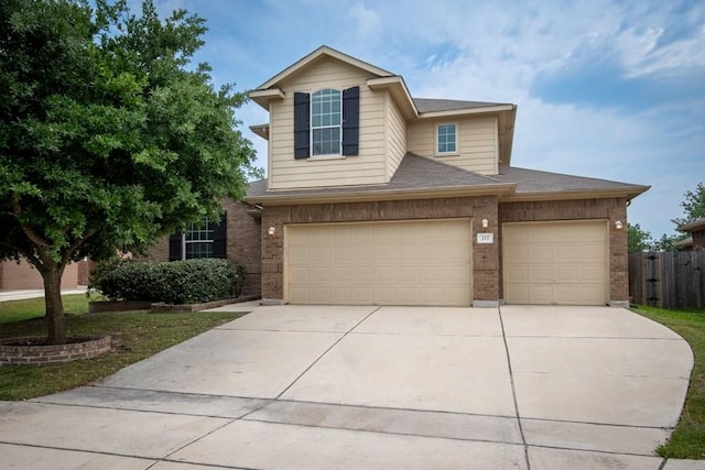 217 Orchard Hill Trl, Buda, TX 78610 - traditional home with brick siding, driveway, fence, and a garage