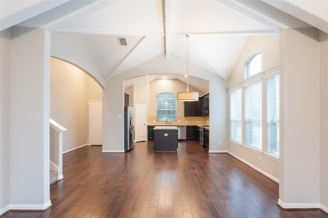 217 Orchard Hill Trl, Buda, TX 78610 - unfurnished living room featuring a sink, dark wood finished floors, healthy amount of natural light, and arched walkways