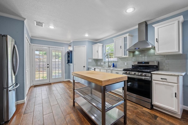 6725 Broad Brook Dr, Austin, TX 78747 - kitchen featuring appliances with stainless steel finishes, wall chimney exhaust hood, a sink, baseboards, and ornamental molding