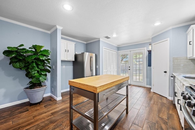 6725 Broad Brook Dr, Austin, TX 78747 - kitchen with stainless steel appliances, french doors, dark wood finished floors, baseboards, and white cabinets