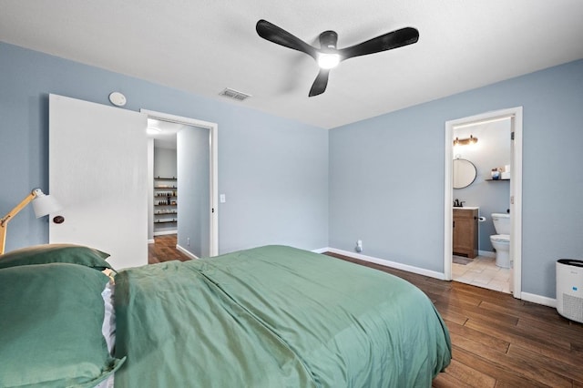 6725 Broad Brook Dr, Austin, TX 78747 - bedroom with wood finished floors, baseboards, ceiling fan, and ensuite bath