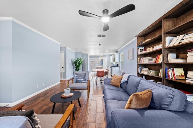 6725 Broad Brook Dr, Austin, TX 78747 - living room with crown molding, baseboards, wood finished floors, and ceiling fan