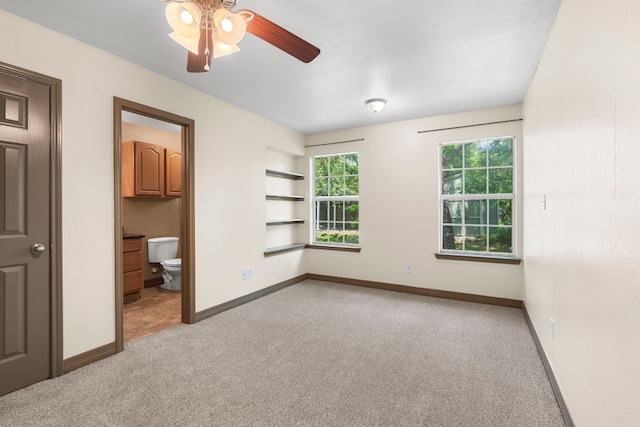 1203 Haynes St, San Marcos, TX 78666 - unfurnished bedroom featuring light colored carpet, connected bathroom, and a ceiling fan