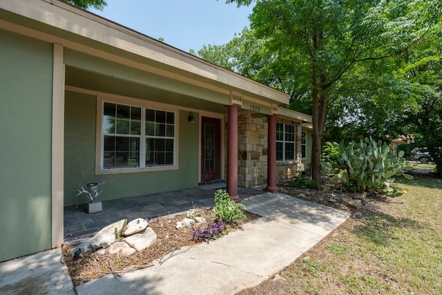 1203 Haynes St, San Marcos, TX 78666 - entrance to property featuring stucco siding, covered porch, and stone siding