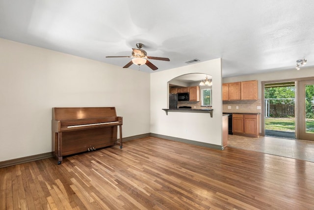 1203 Haynes St, San Marcos, TX 78666 - unfurnished living room featuring light wood-type flooring, ceiling fan, and a chandelier